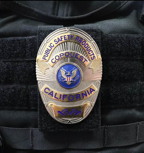 Police badge with the words COPQUEST PUBLIC SAFETY PRODUCTS CALIFORNIA