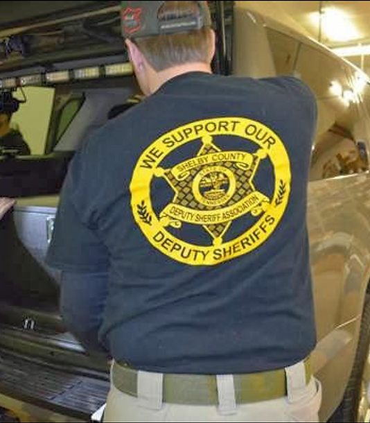 Man standing behind SUV with We Support Our Deputy Sheriffs T-shirt