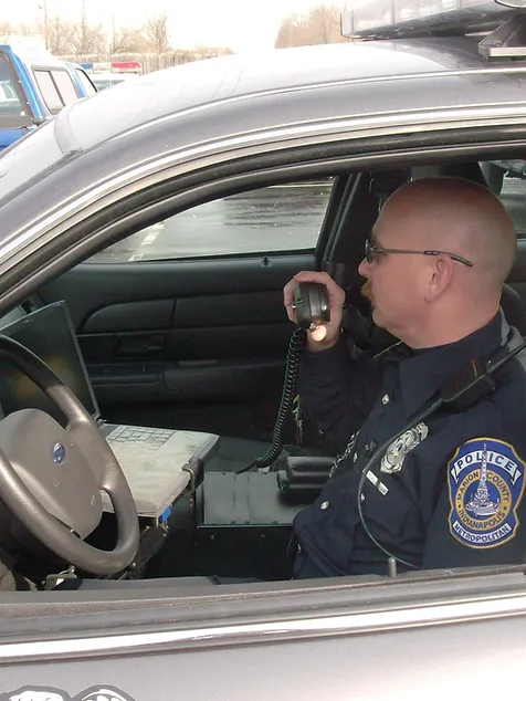 Indianapolis police officer in cruiser talking on radio